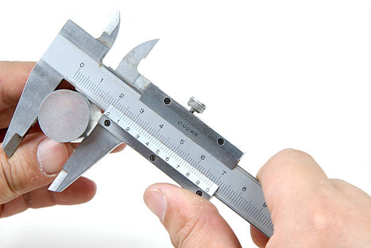 Inspector measuring a cast part with a vernier caliper